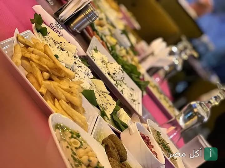 مائدة إفطار شرقي متنوعة تضم أطباق البطاطس المقلية والجبن والمقبلات في مطعم ومقهى ستوريا بمدينة نصر.