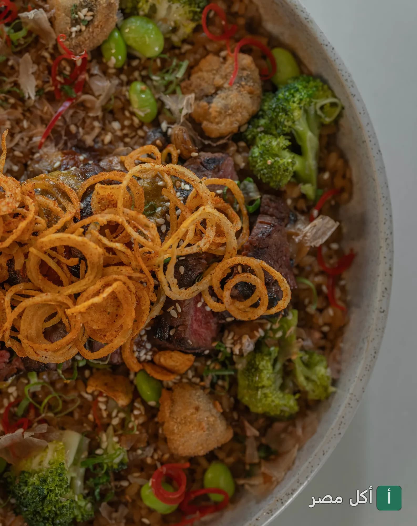 طبق أرز مقلي مع شرائح اللحم والبروكلي والبصل المقرمش في مطعم كازوكو بالتجمع الأول.