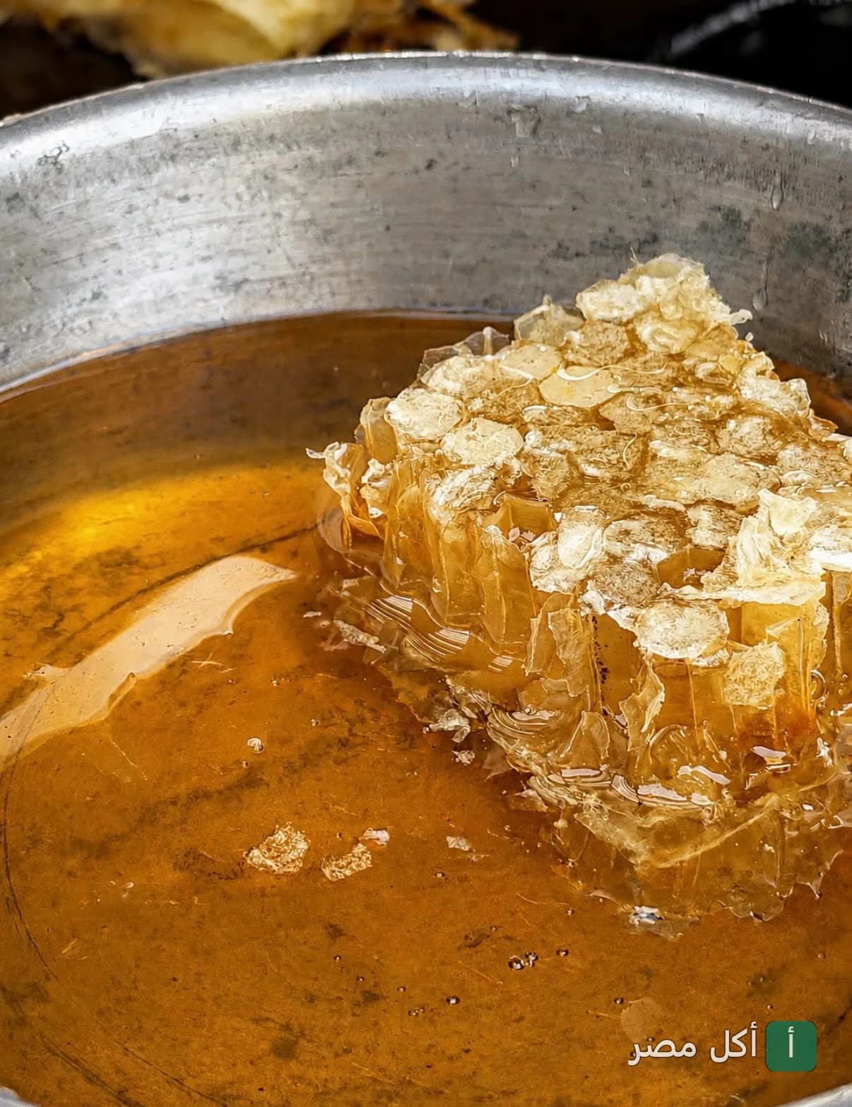 قطعة من شمع العسل الطبيعي مغمورة في عسل صافي بمطعم إيتري في كايرو فستيفال سيتي.