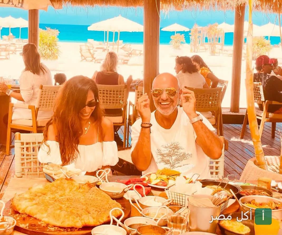 أشخاص يستمتعون بوجبة متنوعة في مطعم إيتري المطل على الشاطئ في كايرو فستيفال سيتي.