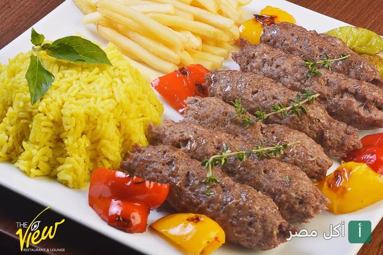 طبق كفتة مشوية مع أرز أصفر وبطاطس مقلية وفلفل ألوان في مطعم ذا فيو بالقاهرة