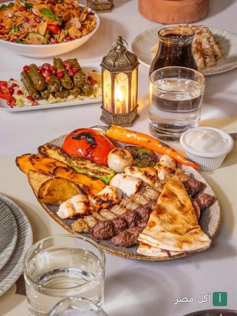 سفرة رمضانية متنوعة من مطعم عنب بيروت في فيليج مول، تضم مشويات مشكلة، ورق عنب، وفتوش.