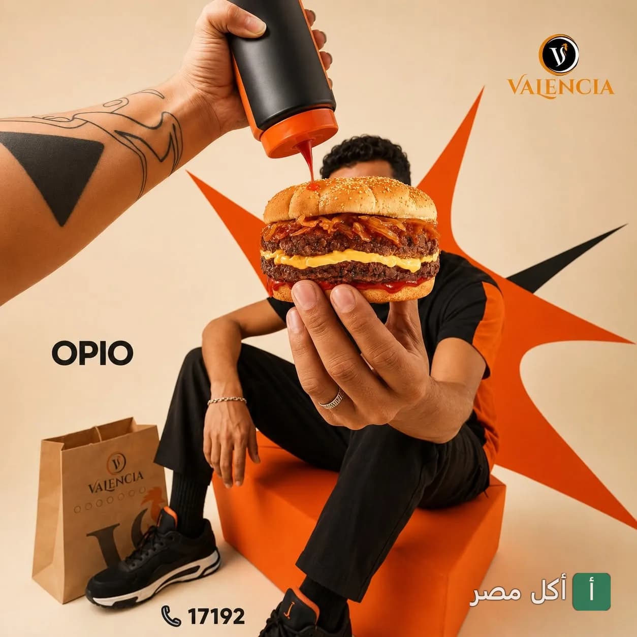 شخص يمسك برجر مزدوج من مطعم فالنسيا وسط البلد مع صوص ينسكب عليه، بجانبه كيس التيك أواي الخاص بالمطعم.
