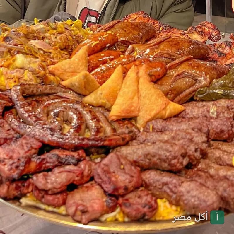 صينية مشويات مشكلة تضم كفتة، سجق، ومقبلات في مطعم أرض الحضارة بالمنيل الغربي.