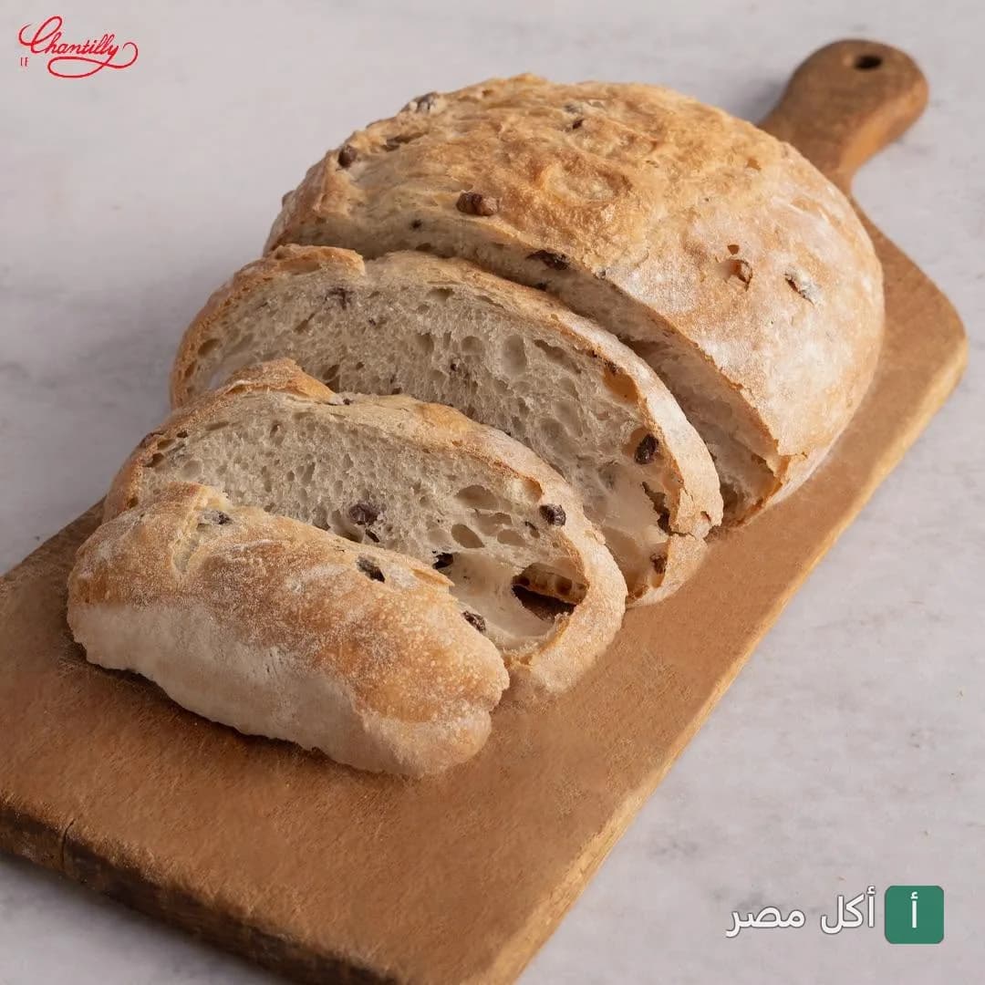 رغيف خبز طازج مقطع على لوح خشبي في مطعم لوشانتى بالقاهرة.
