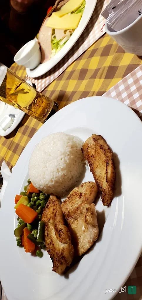 طبق أرز مع قطع دجاج مشوية وخضار سوتيه في مطعم لا تشيزا بوسط البلد القاهرة.