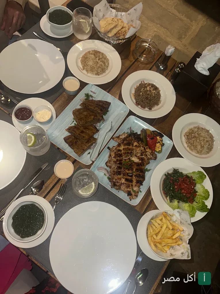 مائدة طعام متنوعة تضم أطباق مشويات وأرز ومقبلات شرقية في مطعم سيروكو بالقاهرة.