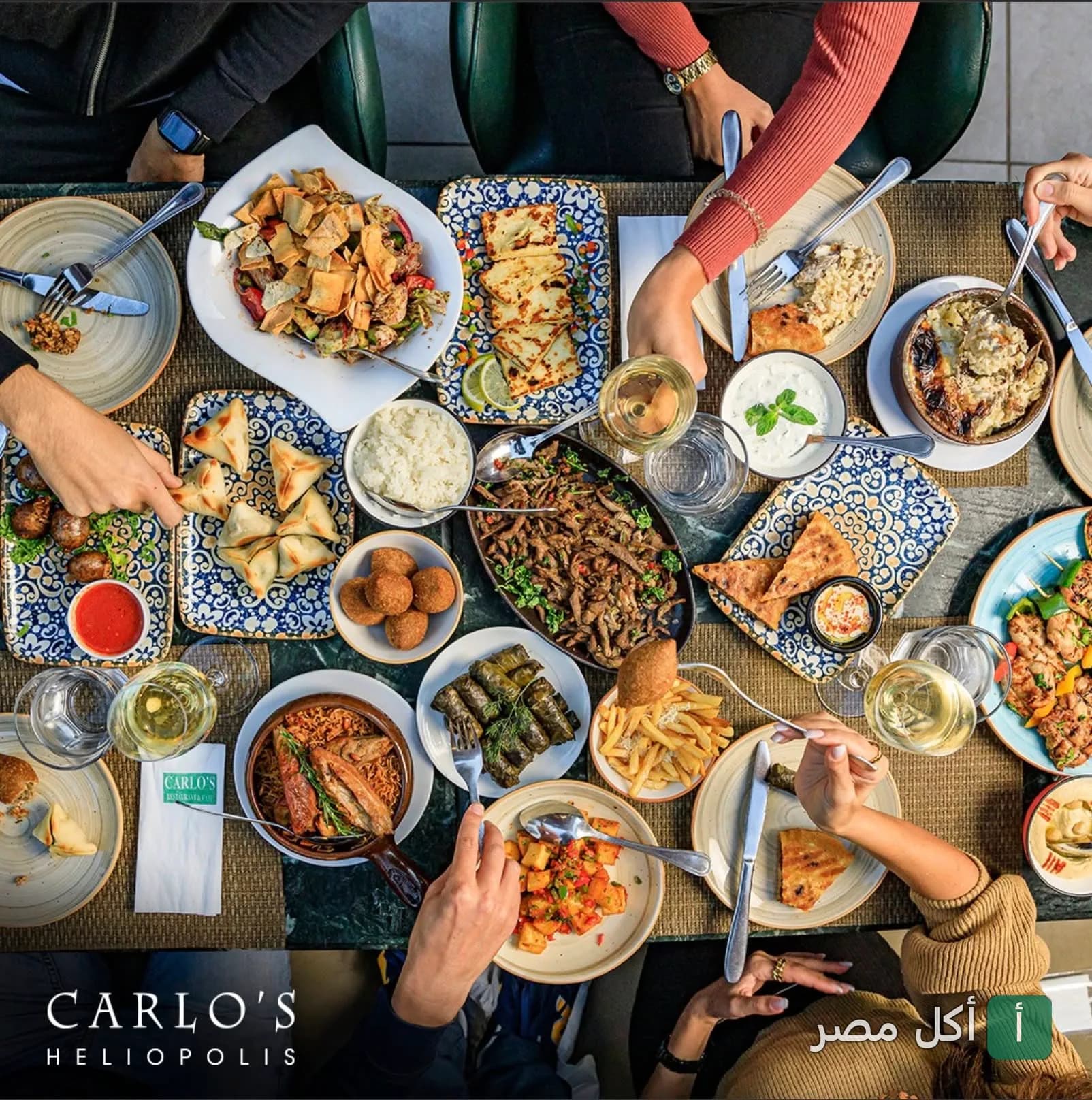مائدة طعام متنوعة تضم أطباقاً شرقية ومقبلات في مطعم وكافيه كارلوز بمصر الجديدة.