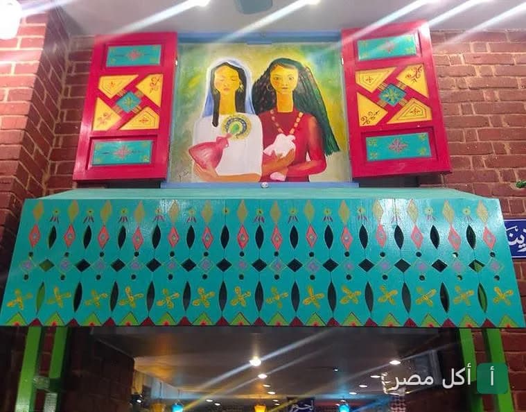 ديكور فني ملون يضم لوحة لفتاتين فوق واجهة مطعم فلفلة إكسبريس في باب اللوق بالقاهرة.