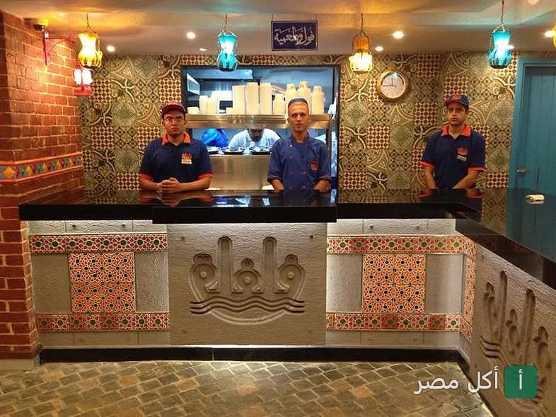 موظفو مطعم فلفلة إكسبريس يقفون خلف كاونتر التقديم المزخرف في فرع باب اللوق بالقاهرة.