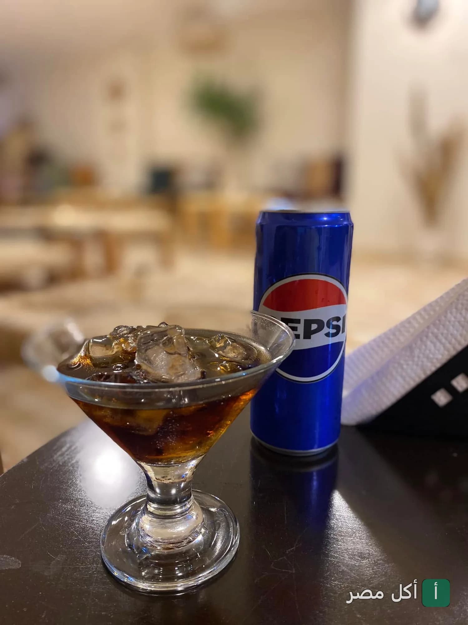 كوب بيبسي مثلج بجانبه علبة بيبسي في مطعم وكافيه انبسا بالدقي.