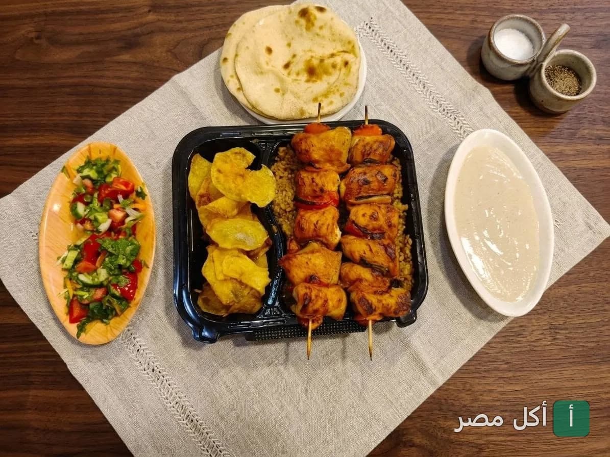 وجبة شيش طاووق مع أرز وسلطة وطحينة وخبز من مطعم أسماك أبو عرفة في الجيزة