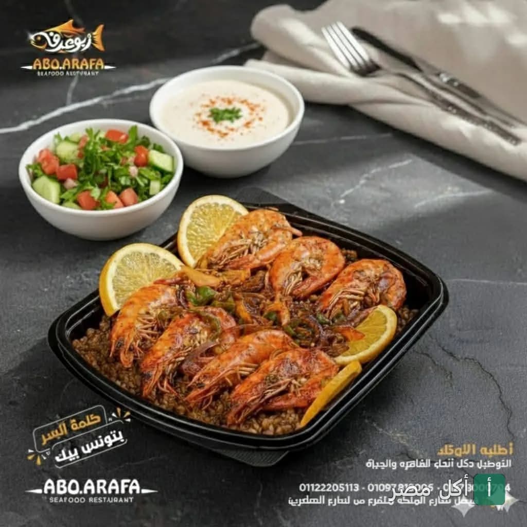 طبق جمبري مشوي مع أرز الصيادية وشرائح الليمون من مطعم أسماك أبو عرفة بالجيزة، يقدم مع سلطة خضراء وطحينة.