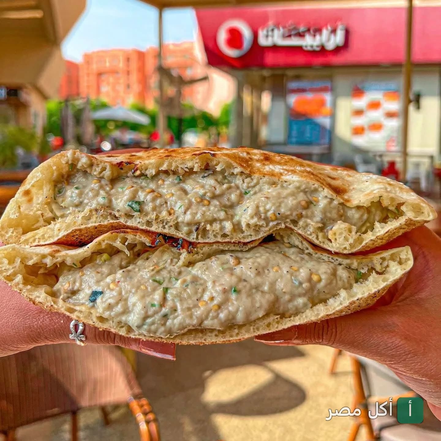 ساندوتش بابا غنوج في خبز بلدي أمام واجهة مطعم أرابياتا شبراوي.