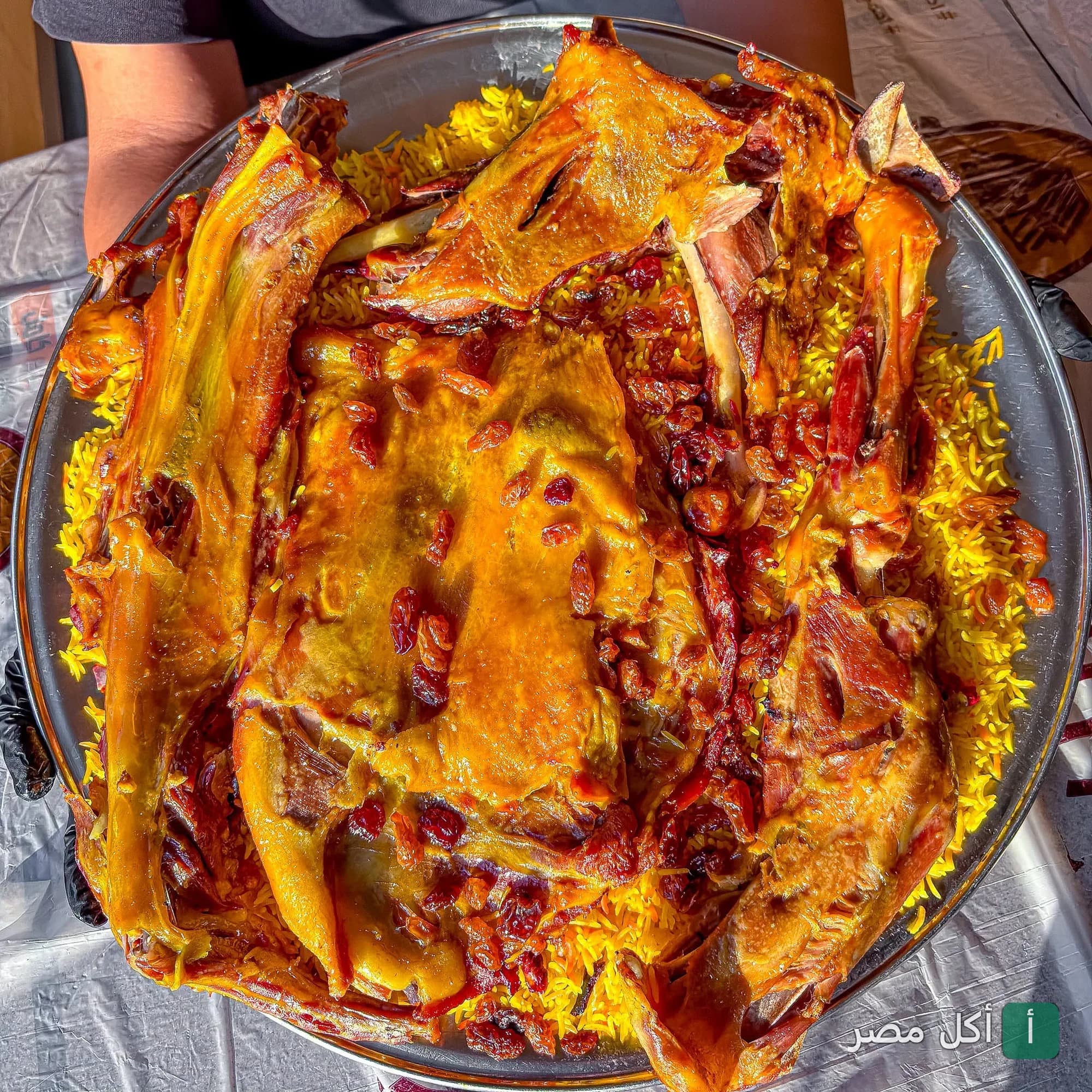 صينية كبيرة من لحم الضأن المشوي مع الأرز الأصفر والزبيب في مطعم حضر موت والسمار بالدقي.