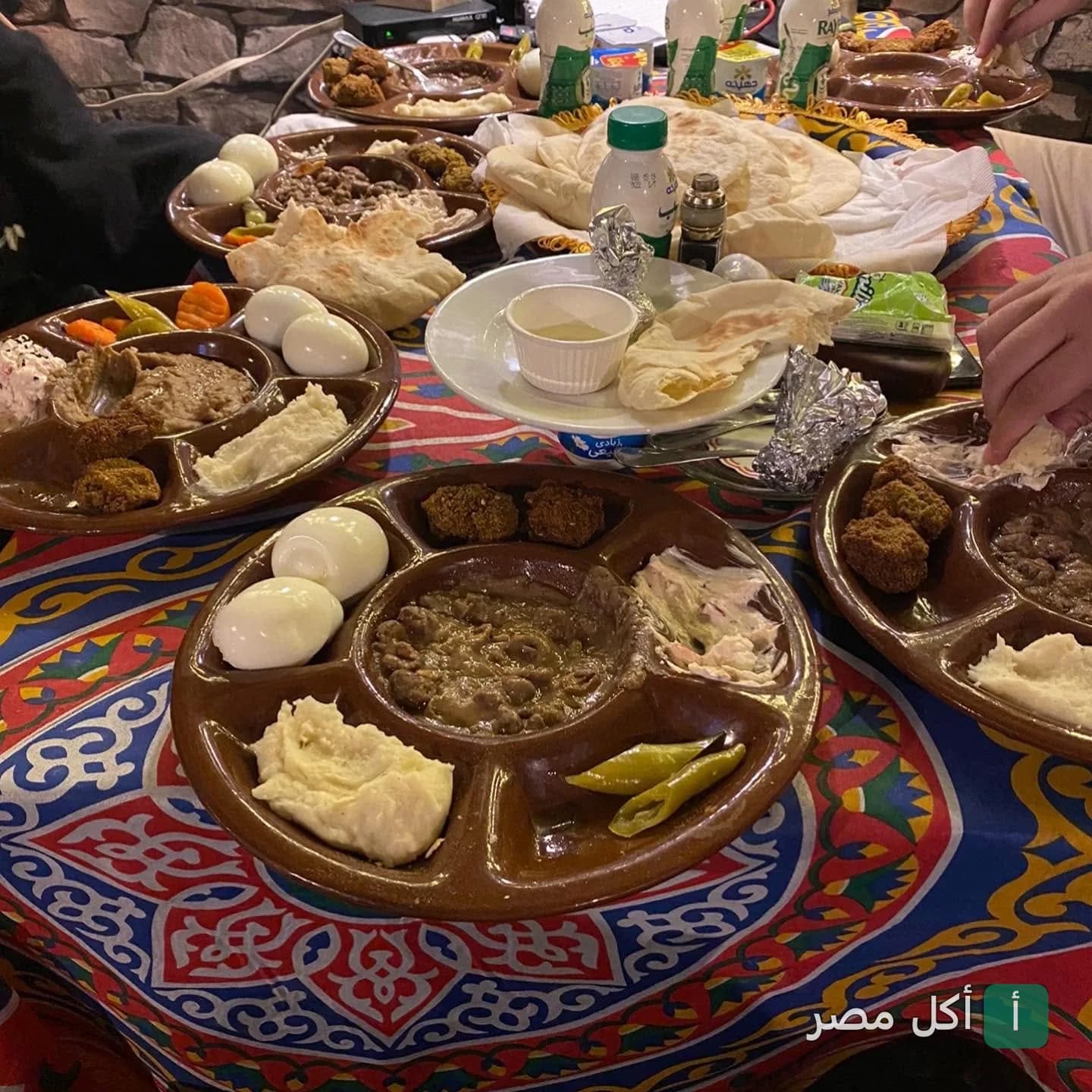سفرة فطار مصري تقليدي بأطباق مقسمة تحتوي على فول وطعمية وبيض مسلوق في مطعم سيف هاوس بالدقي.