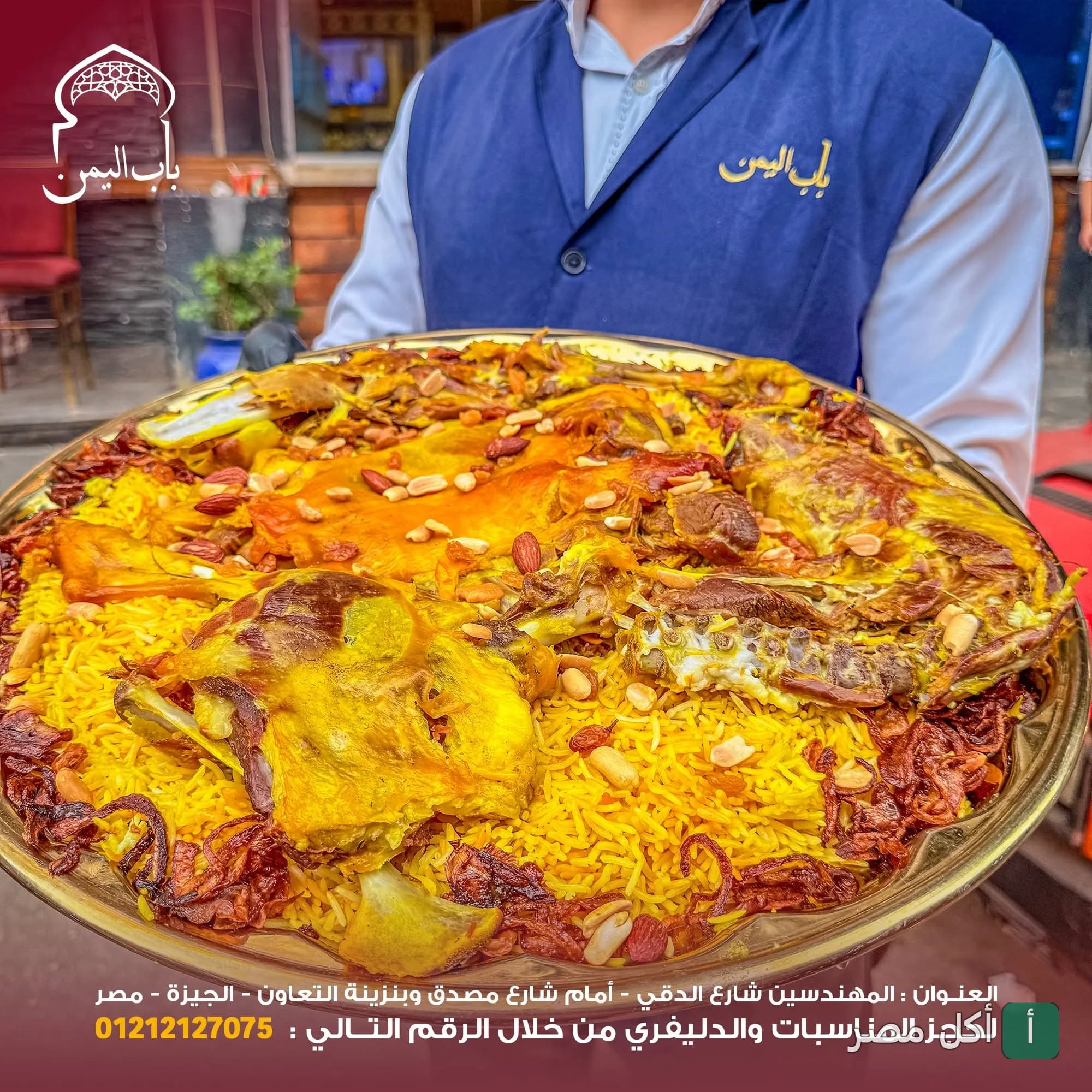 نادل في مطعم باب اليمن بالدقي يقدم صينية كبيرة من الأرز باللحم والمكسرات