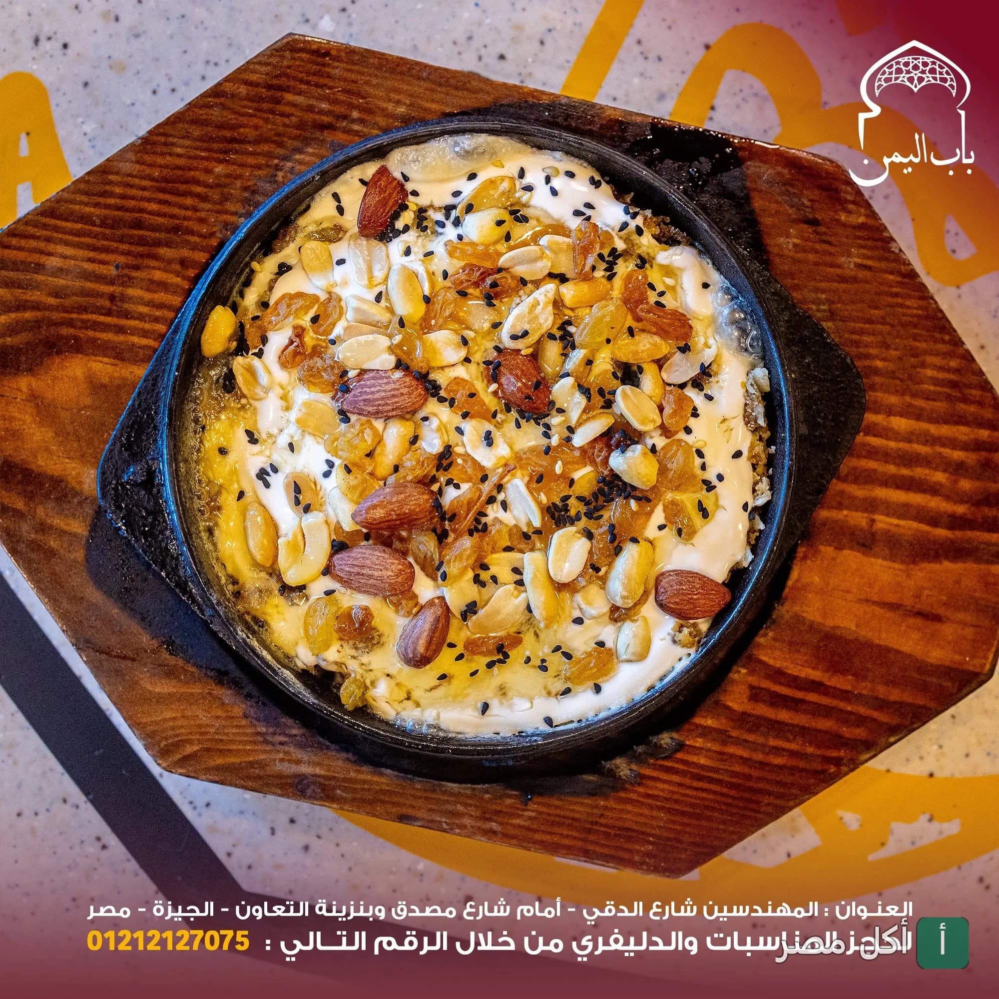 طبق شرقي ساخن يقدم في مقلاة حديدية مع المكسرات والزبيب من مطعم باب اليمن بالدقي.
