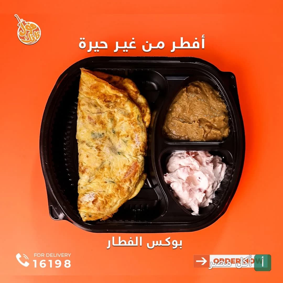 وجبة إفطار من مطعم فول تانك بالدقي تحتوي على أومليت وفول وسلطة في علبة مقسمة.