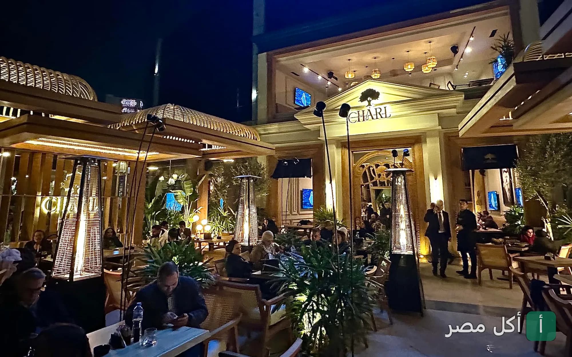 جلسات خارجية مضيئة في مطعم شارل بمدينة 6 أكتوبر ليلاً.