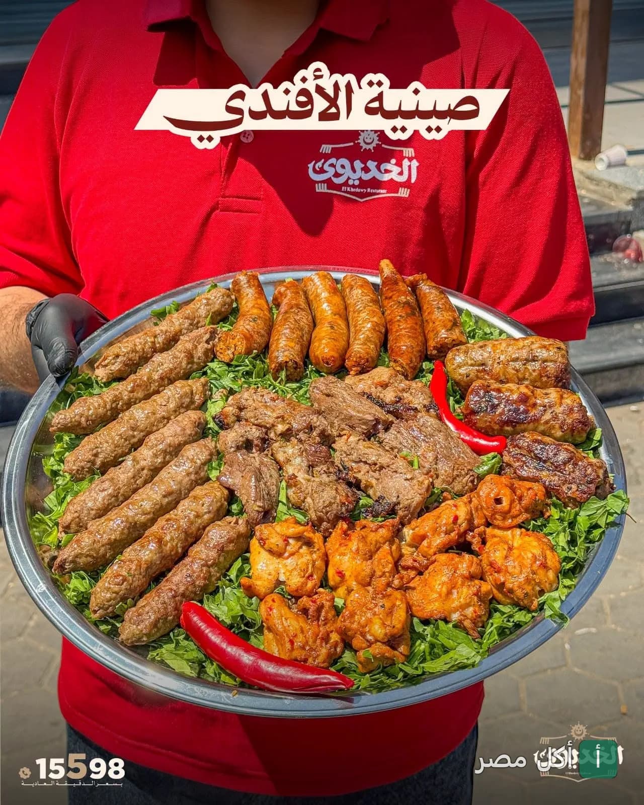 موظف مطعم الخديوي في أكتوبر يقدم صينية الأفندي المشكلة من المشويات على فرشة بقدونس.