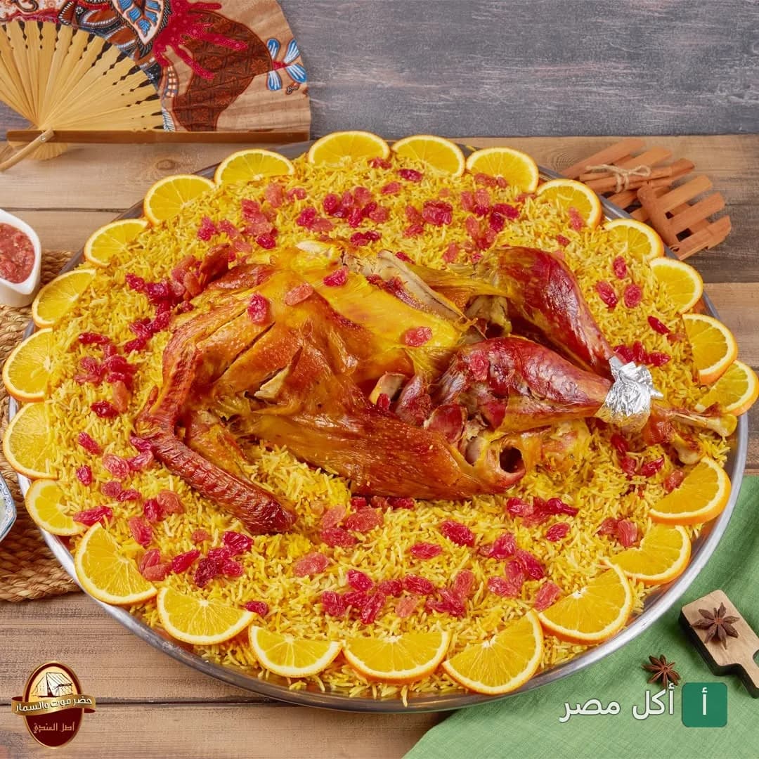طبق أرز مبهر مع دجاج محمر مزين بقطع البرتقال والزبيب في مطعم حضرموت والسمار بـ 6 أكتوبر.