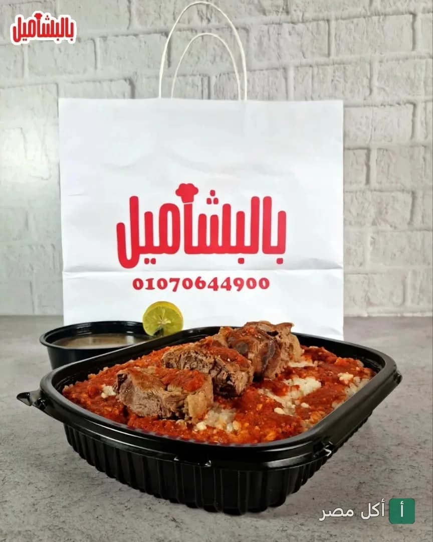 وجبة لحم بالصلصة في علبة تيك أواي أمام كيس مطعم بالبشاميل في 6 أكتوبر