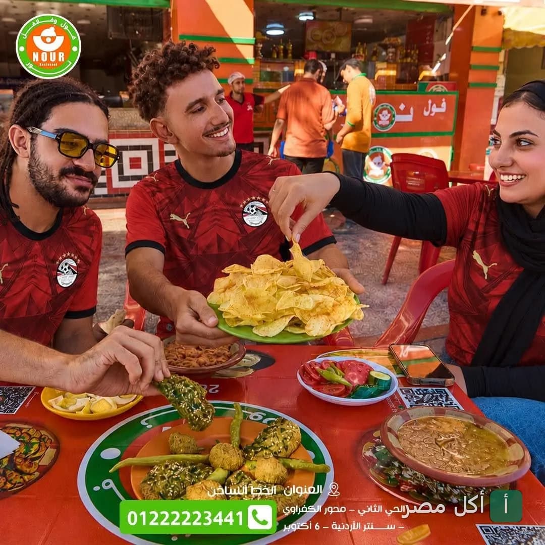 مجموعة أصدقاء يرتدون قمصان المنتخب المصري يتناولون الفول والطعمية في مطعم نور في 6 أكتوبر.