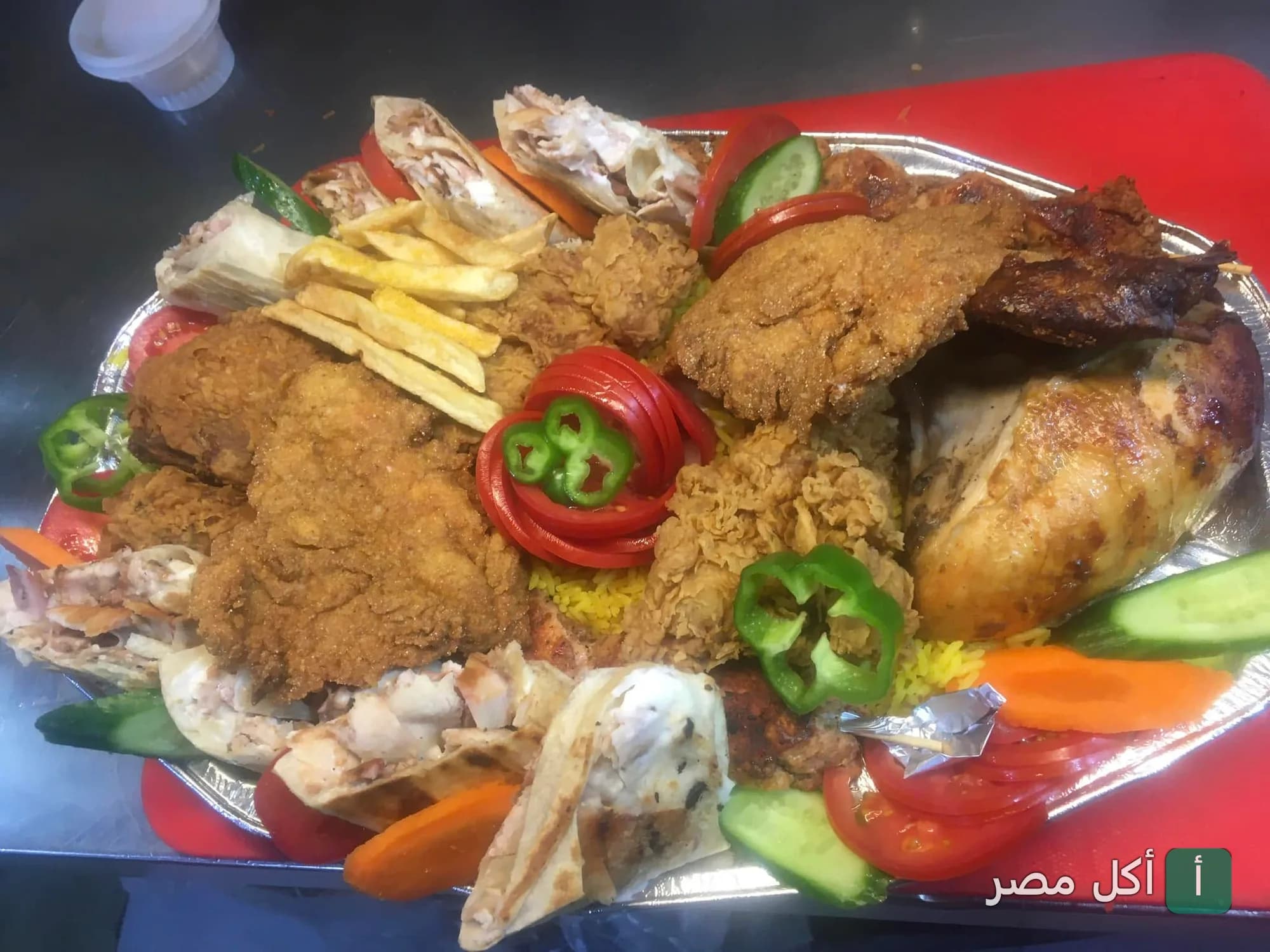 طبق مشكل من الشيف السوري في 6 أكتوبر يحتوي على دجاج مقلي، شاورما، وأرز مبهر مع خضروات.