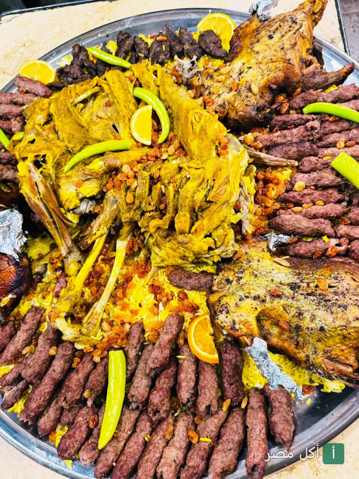 صينية عزومة كبيرة من مطعم حضرموت أطفيح تحتوي على لحم مشوي وكفتة وأرز بالمكسرات.