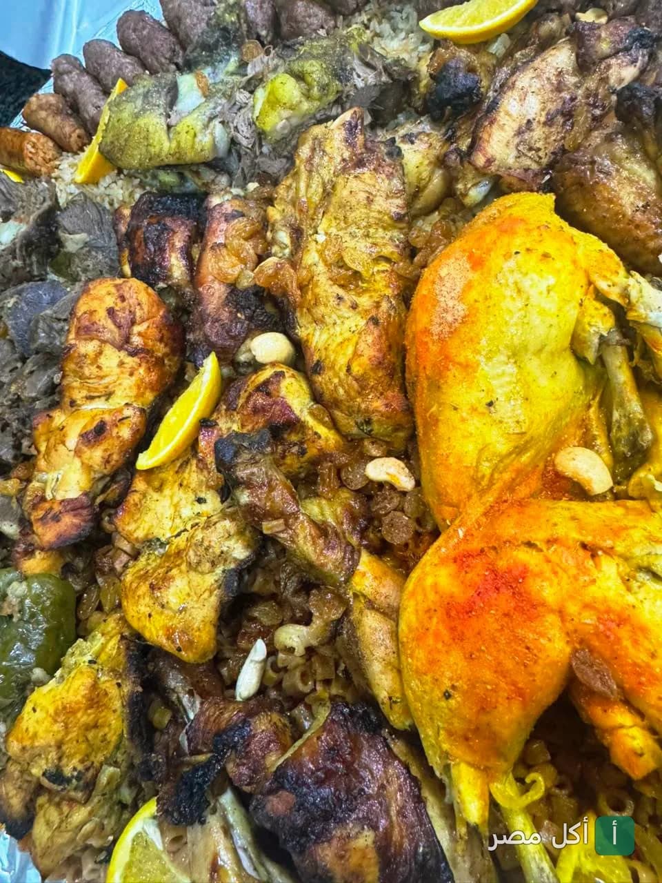 صينية مشويات متنوعة مع أرز حضرموت من مطعم حضرموت اطفيح، تضم دجاج مشوي وكفتة وقطع لحم مع المكسرات والليمون.