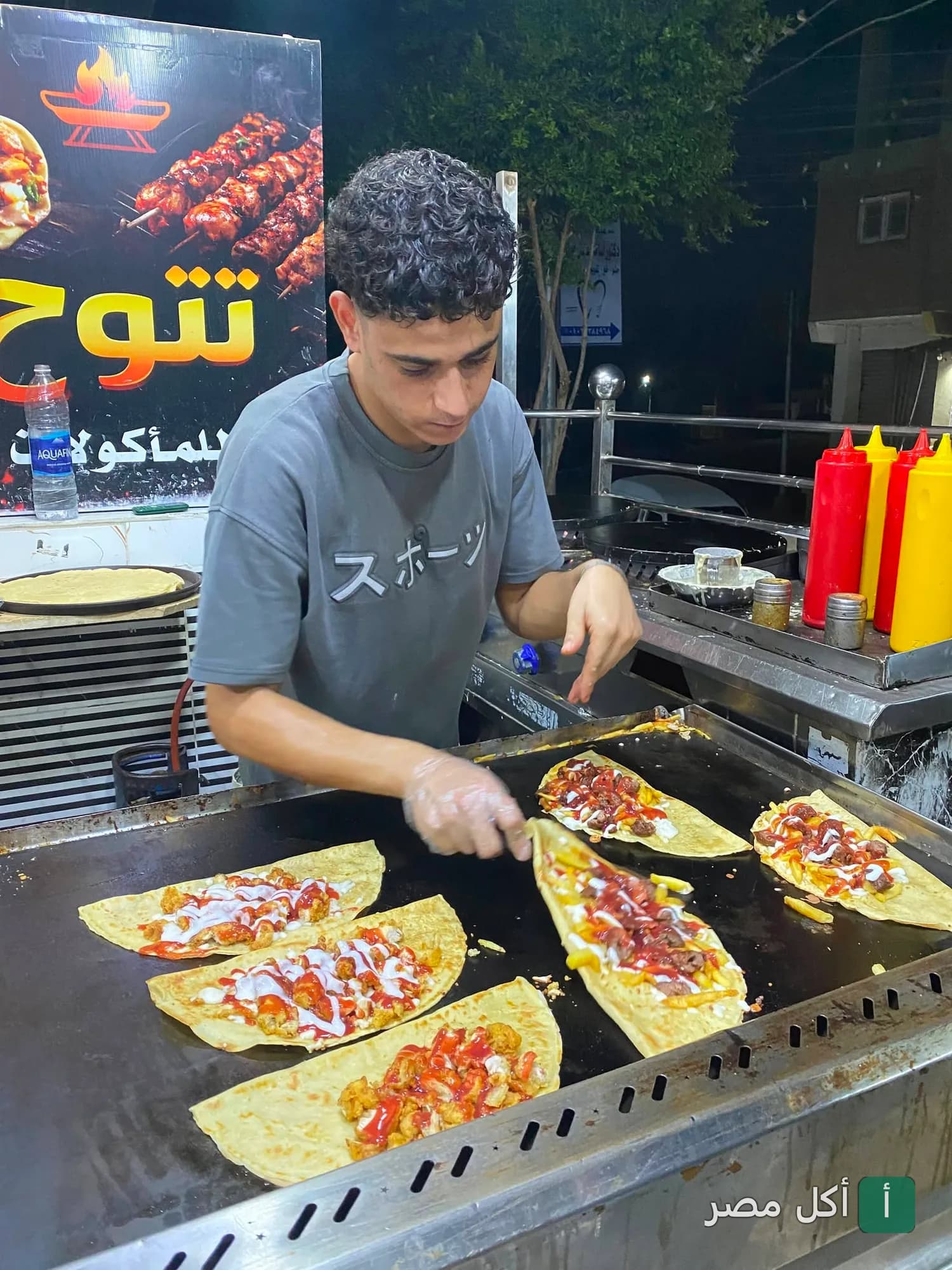 طباخ يحضر ساندوتشات على الصاج في مطعم تتوح للمأكولات في أطفيح
