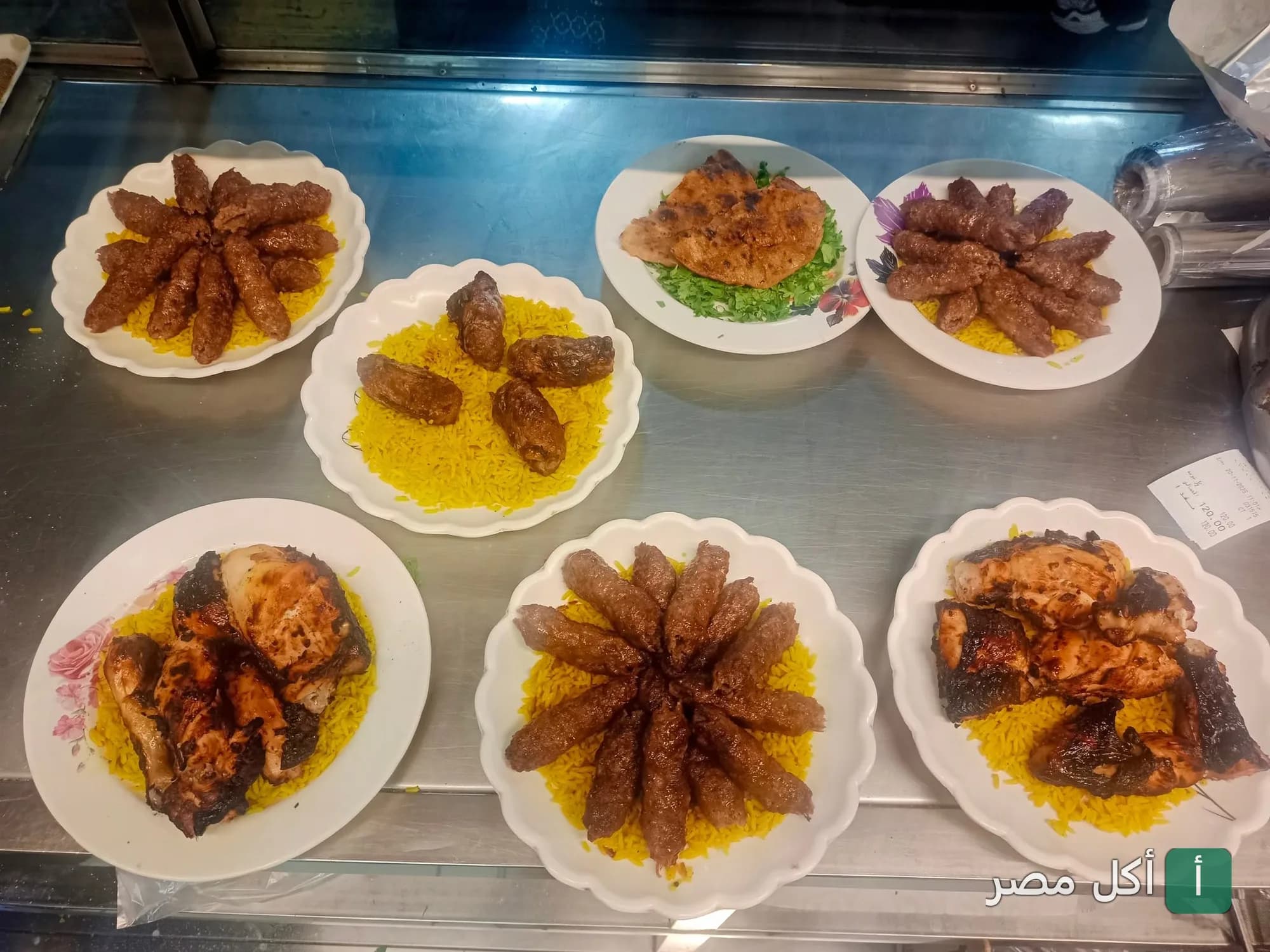 أطباق مشويات متنوعة من كفتة ودجاج مشوي مع أرز أصفر في مطعم عبدين بأطفيح.