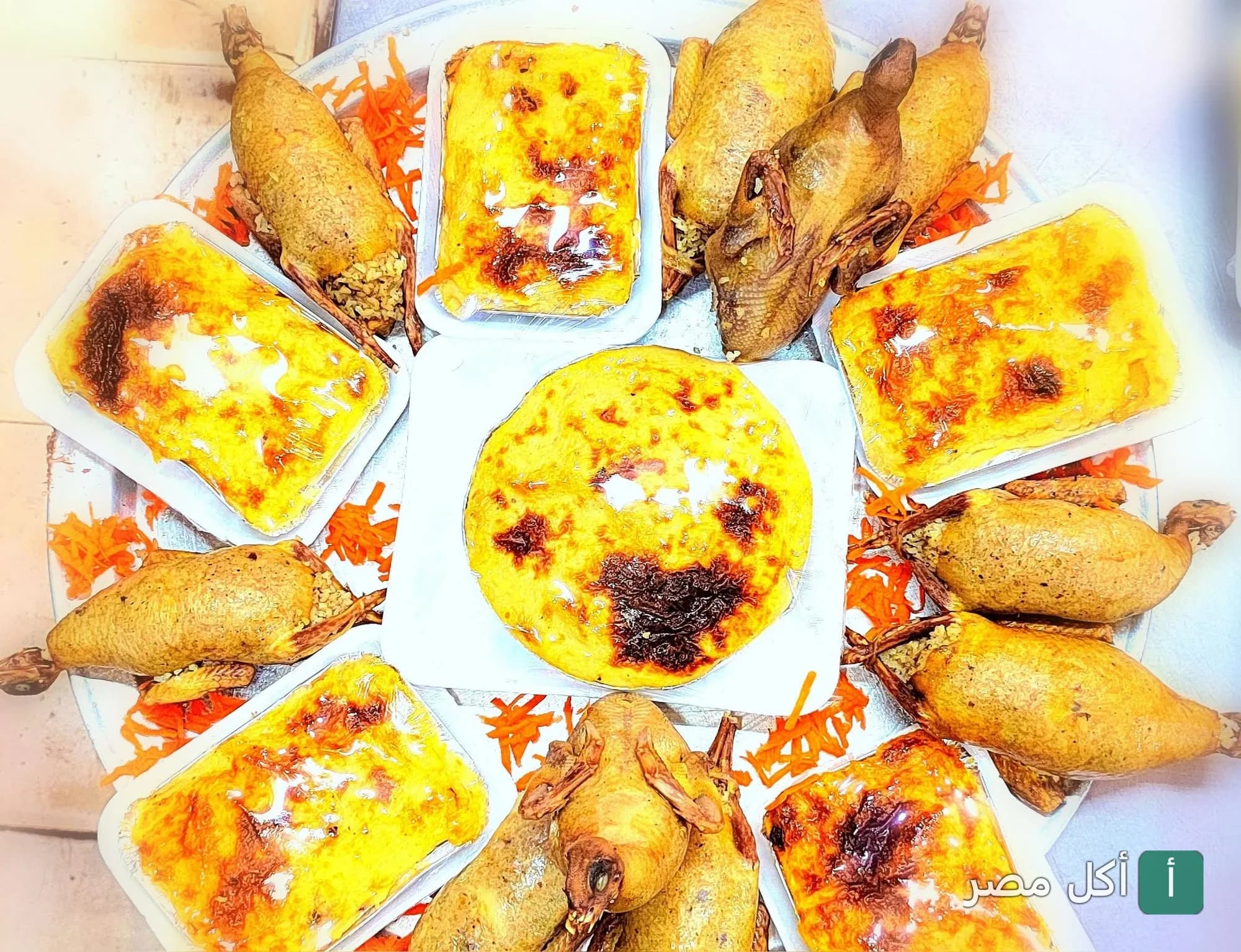 صينية كبيرة من مطعم عبدين في أطفيح تحتوي على حمام محشي وأطباق أرز معمر.