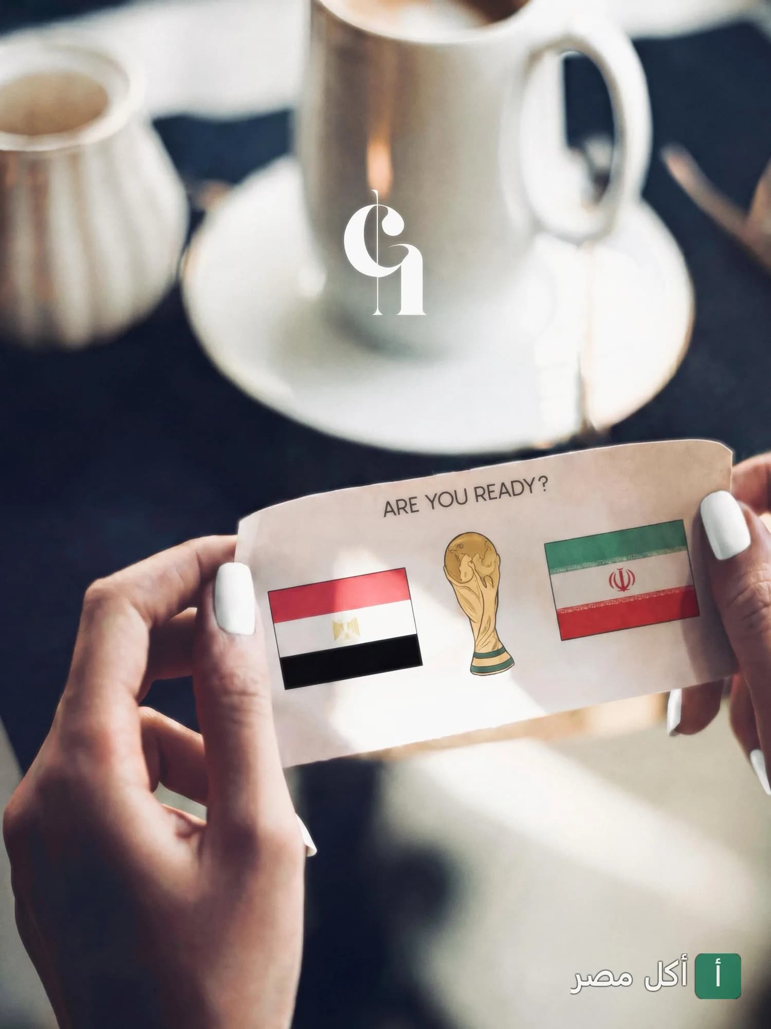 شخص يمسك ورقة عليها أعلام مصر وإيران وكأس العالم في مطعم تشيرلي كوربه.