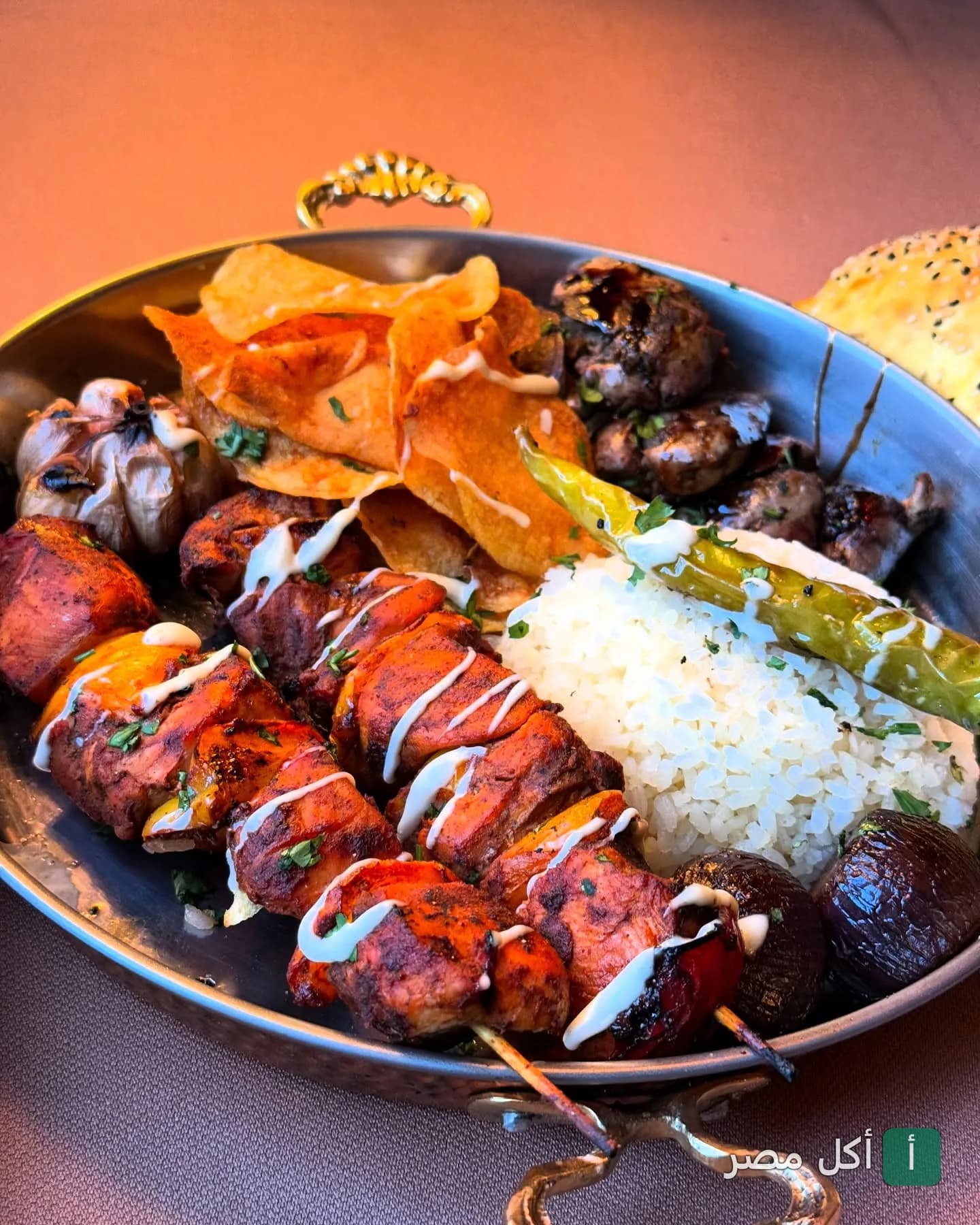 طبق مشاوي مشكل من مطعم تري ترانك يضم شيش طاووق وأرز وبطاطس محمرة وفلفل مشوي.
