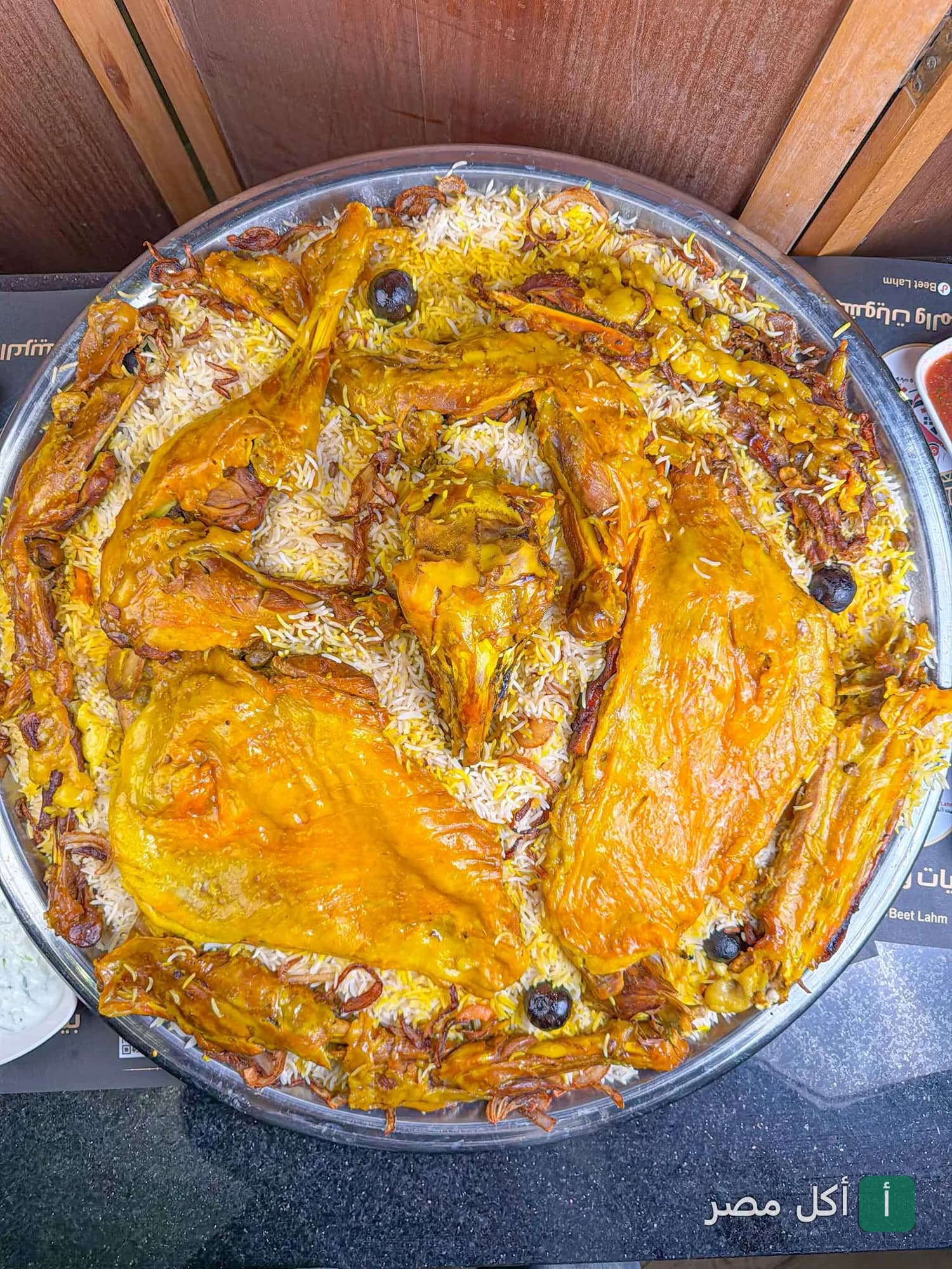 صينية كبيرة من الأرز البسمتي الملون مع لحم الضأن المحمر في مطعم بيت لحم بالجيزة.