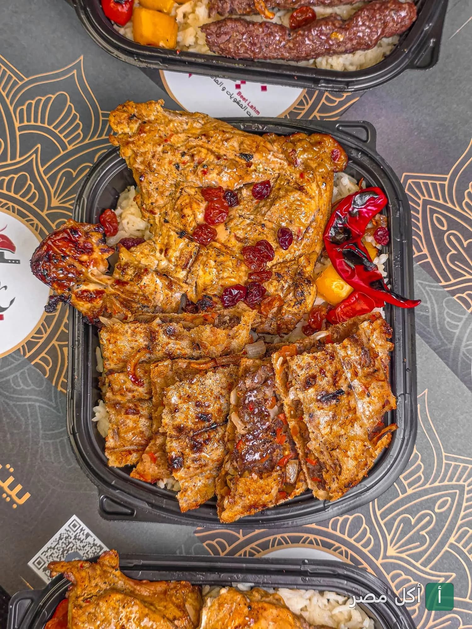 وجبة مشويات متنوعة من مطعم بيت لحم، تضم دجاج مشوي وكفتة مع أرز في علبة تقديم.