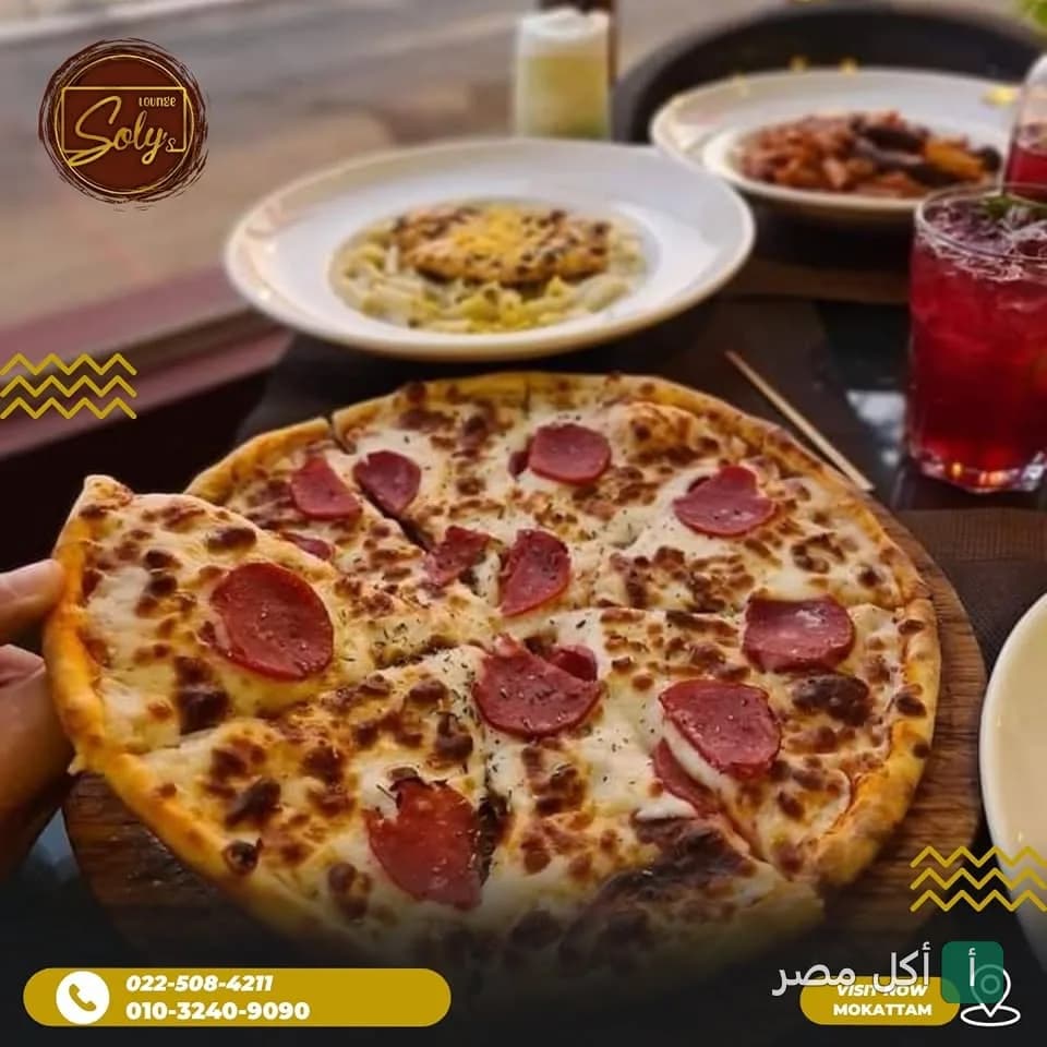 بيتزا بالبيبروني على لوح خشبي في مطعم سولي بالمقطم، مع أطباق جانبية ومشروبات.
