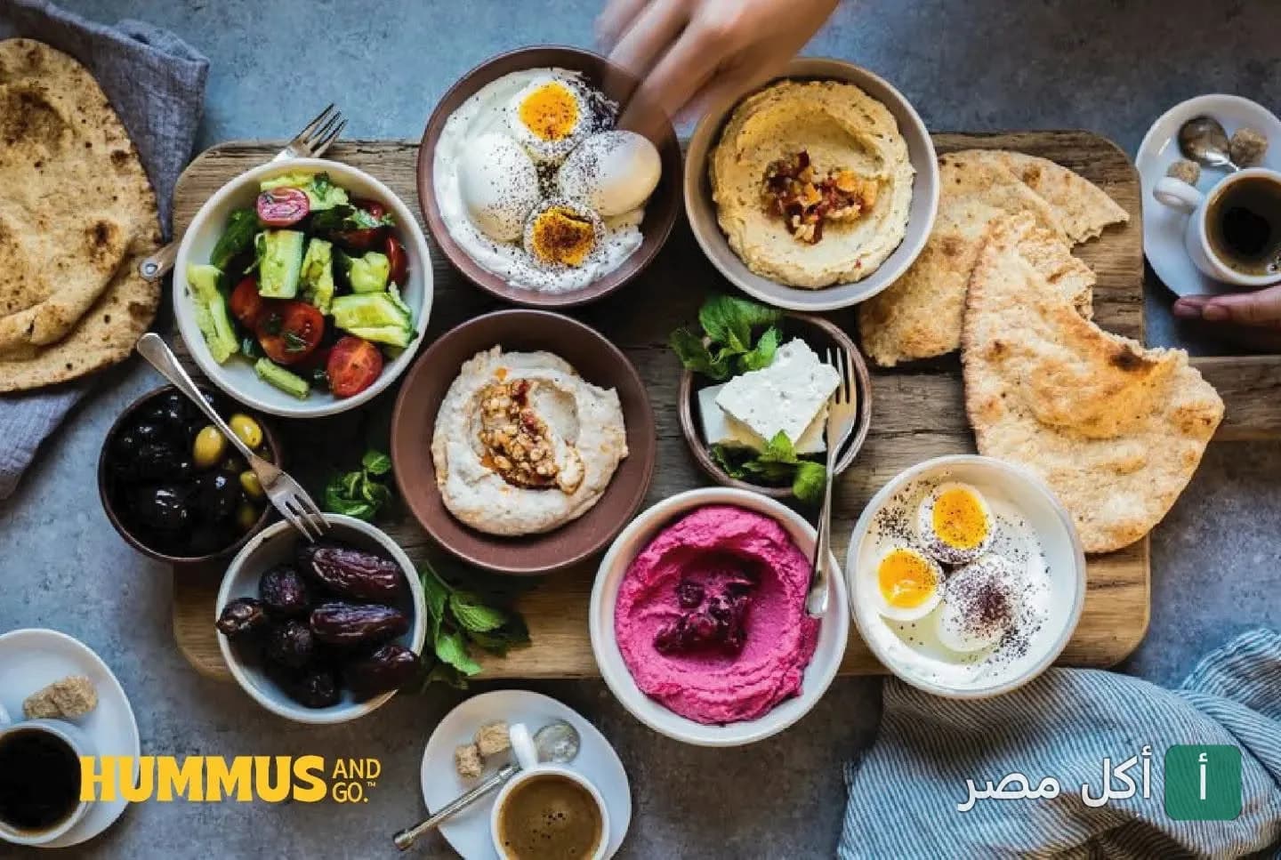 سفرة فطور مصري متنوعة تضم أطباق الحمص والبيض والجبنة والزيتون في مطعم حمص اند جو