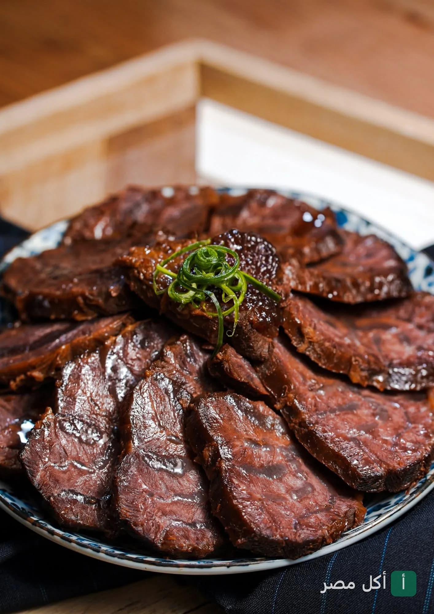 طبق شرائح لحم مشوي بصوص غامق مزين بالبصل الأخضر في مطعم إل دوم لاونج بالأهرام.