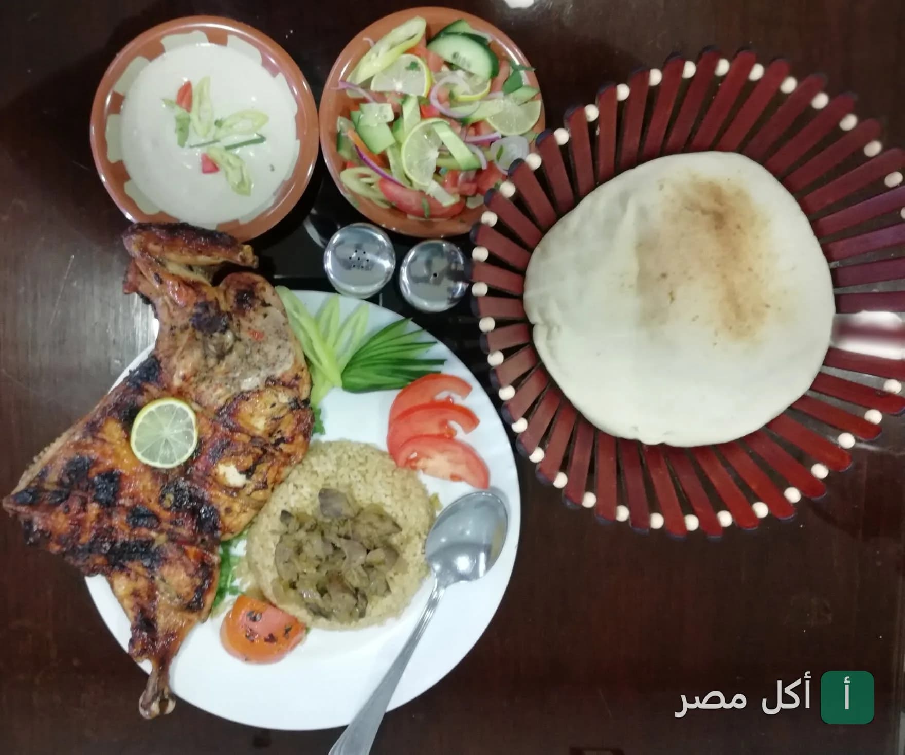 وجبة دجاج مشوي مع أرز وسلطة وخبز طازج في مطعم الحلال بالأهرام.