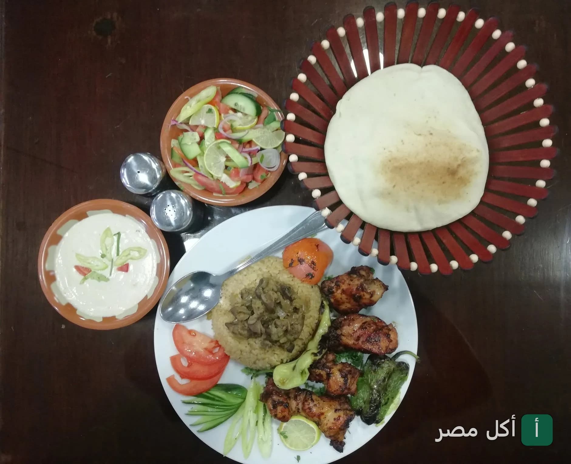 طبق مشويات متنوع مع أرز وسلطات وخبز طازج في مطعم الحلال بالأهرام.