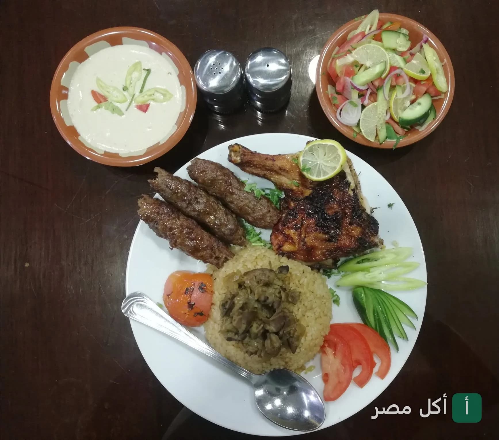 طبق مشويات مشكل من مطعم الحلال في الأهرام يضم كفتة ودجاج مشوي مع أرز وسلطة وطحينة