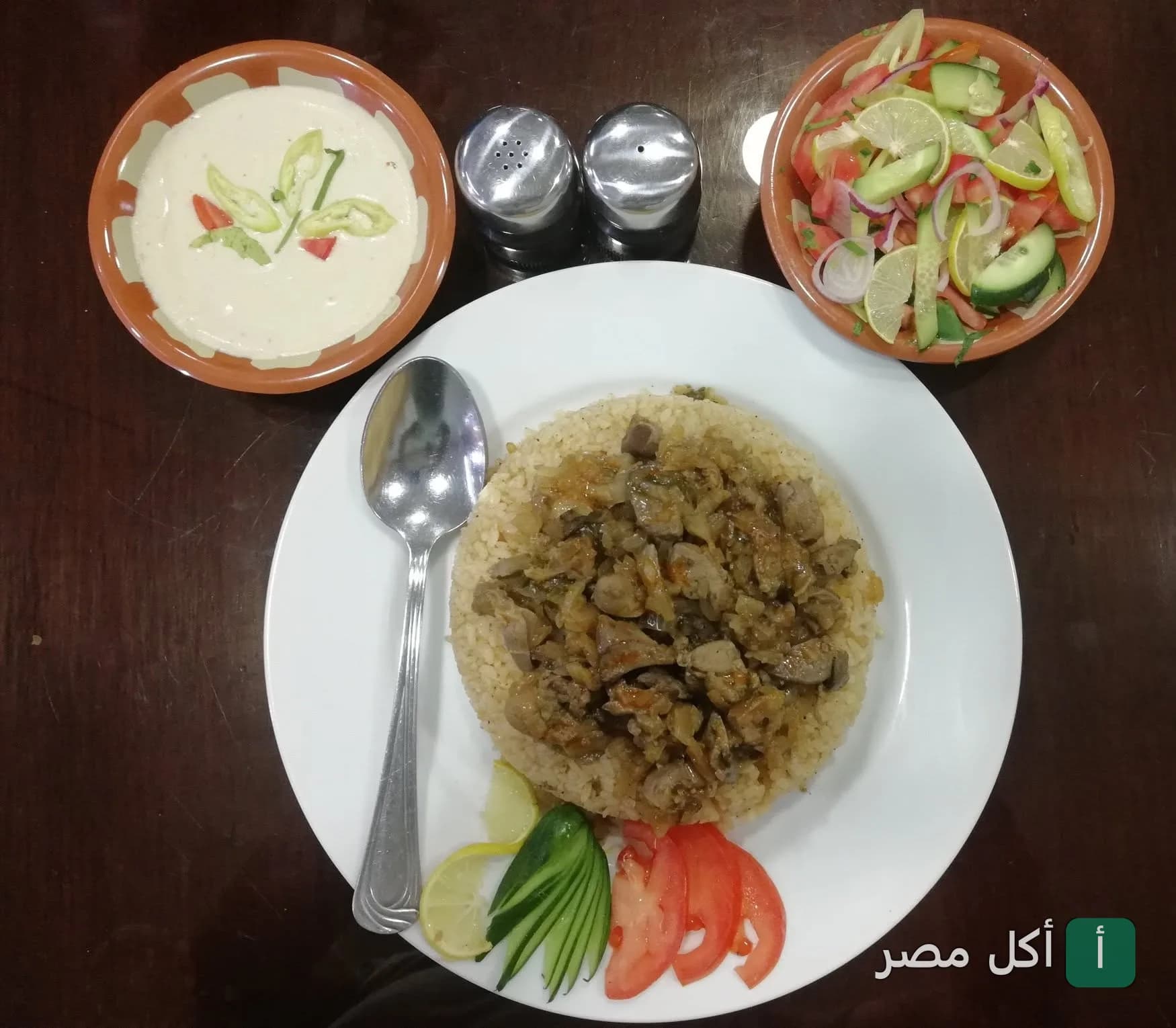 طبق أرز بالكبدة مع سلطة خضراء وطحينة في مطعم الحلال بمنطقة الأهرام