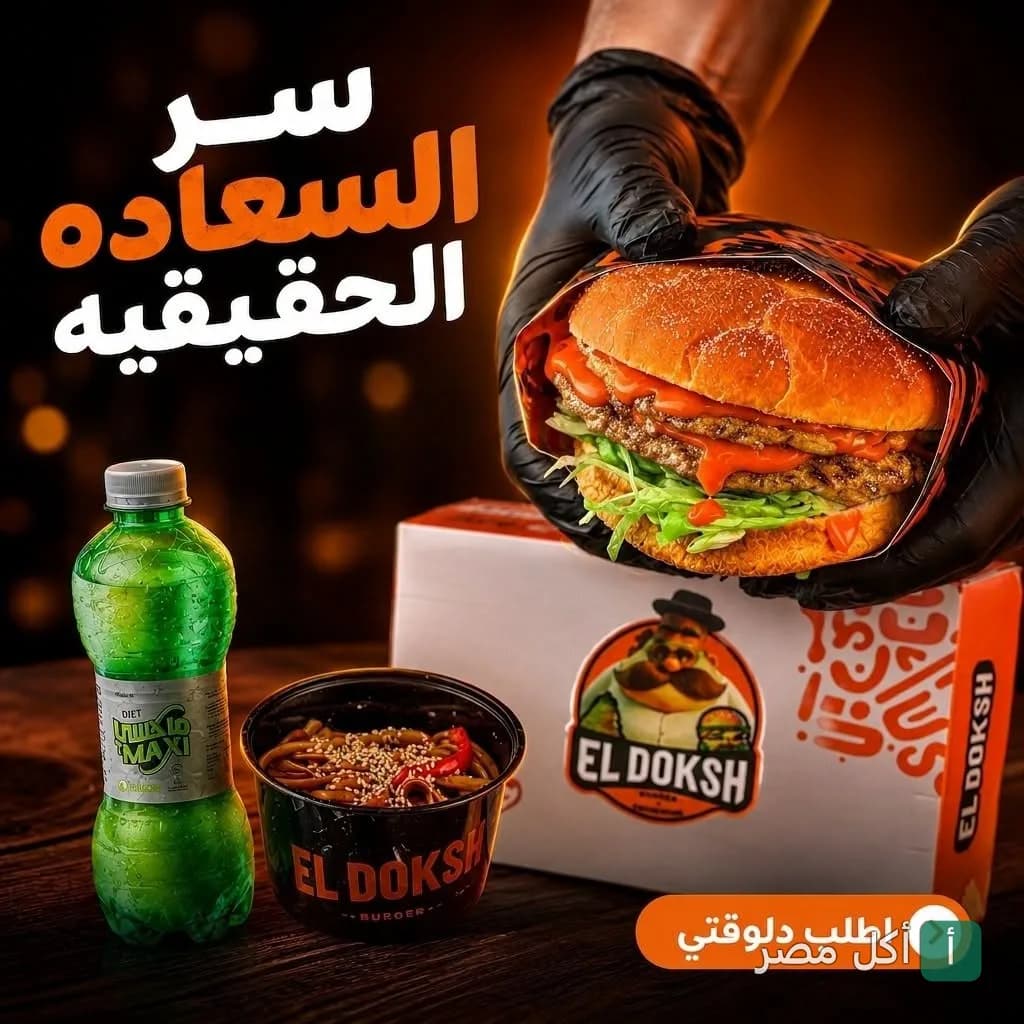 شخص يمسك برجر من مطعم حاتي الدكش مع وجبة جانبية ومشروب غازي.