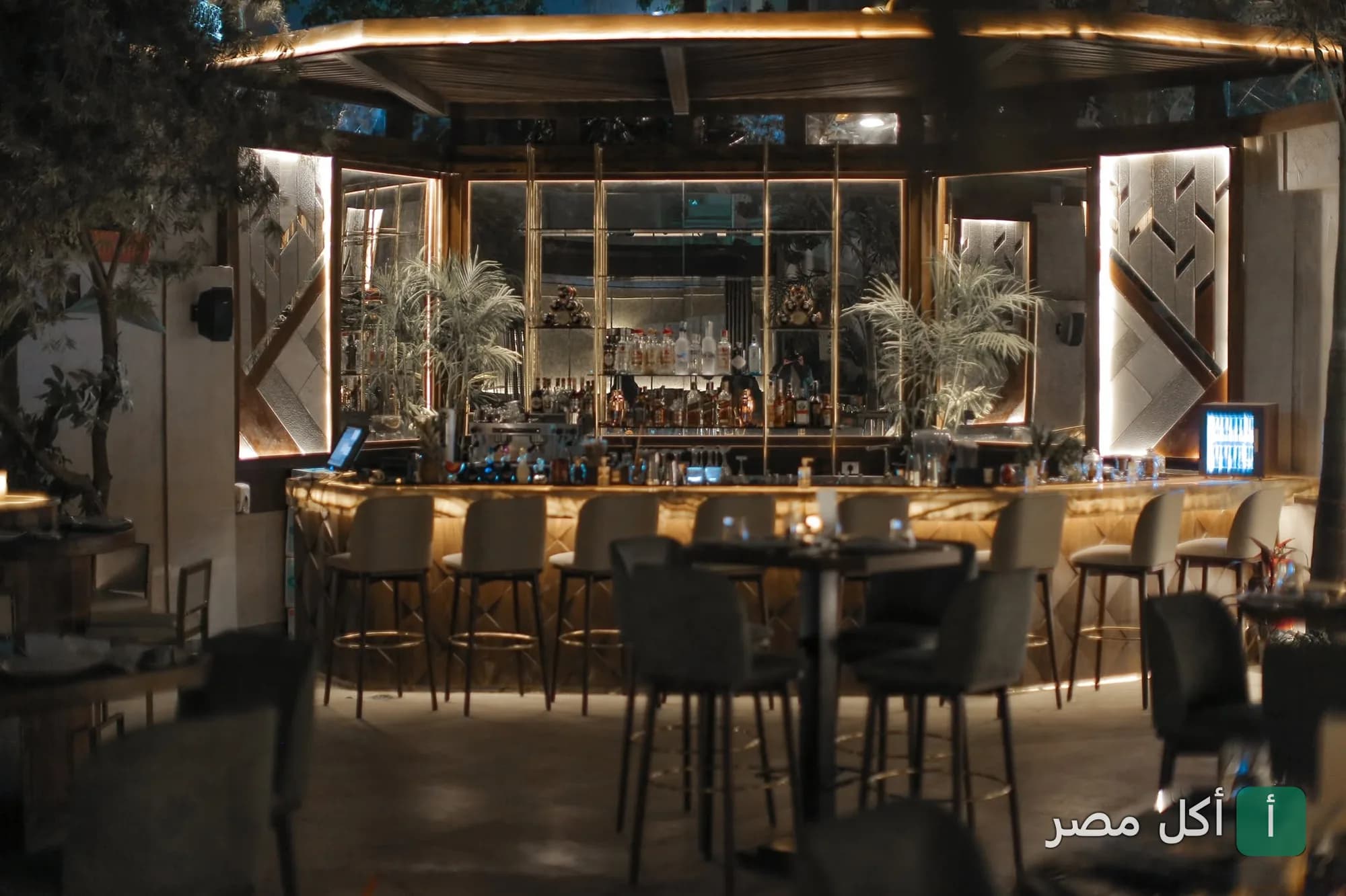 تصميم داخلي أنيق لمنطقة البار في مطعم ذا سموكري بمصر الجديدة مع إضاءة دافئة ومقاعد مرتفعة.