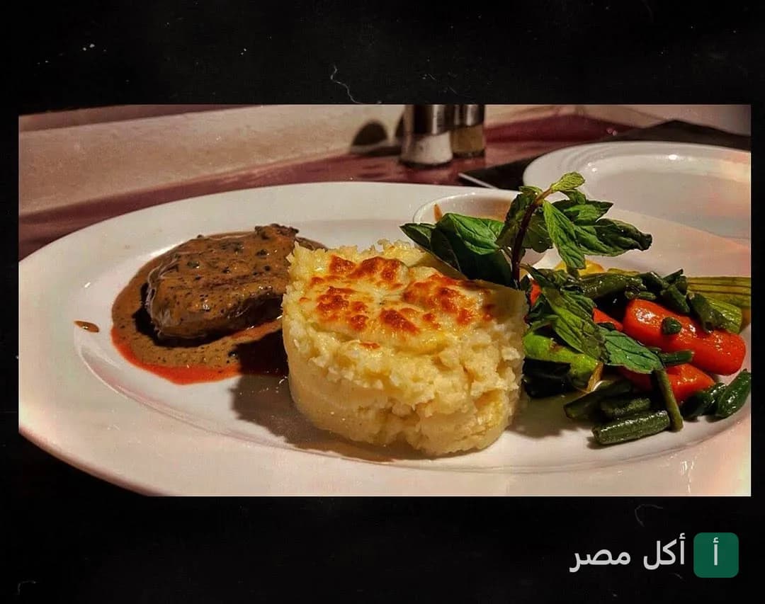 طبق رئيسي من لا كاسيتا بمصر الجديدة يحتوي على شريحة لحم بصوص، بطاطس غراتان، وخضار سوتيه.
