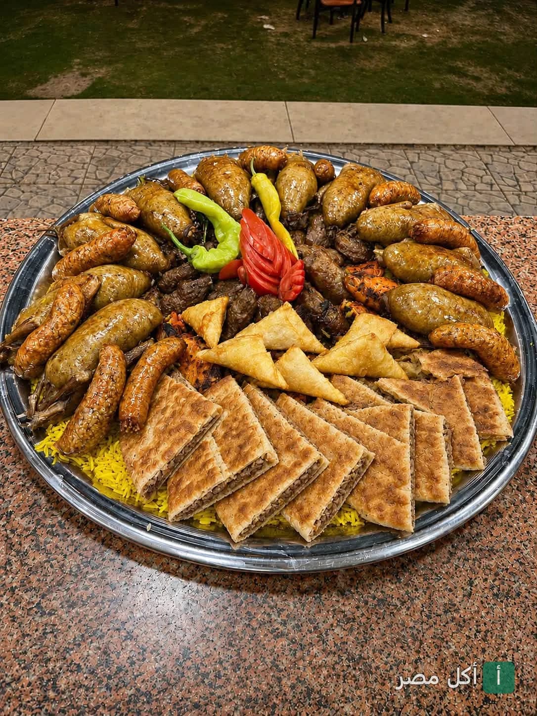 صينية مشويات شرقية متنوعة تحتوي على حمام محشي وممبار وسمبوسك وحواوشي في مطعم رغيف بابا بمصر الجديدة.