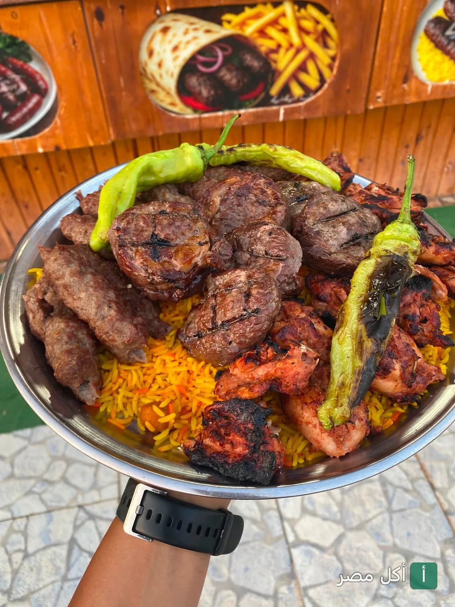 طبق مشويات مشكل من رغيف بابا في مصر الجديدة يضم كفتة وقطع لحم ودجاج مشوي مع أرز أصفر وفلفل حار.